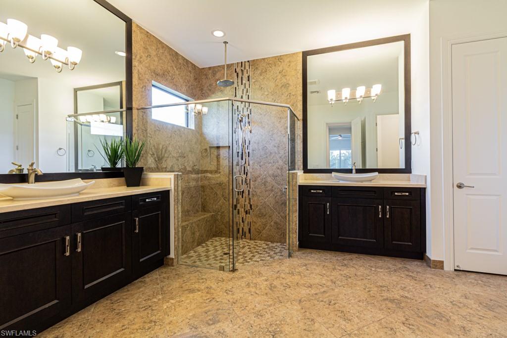 9380 Glenforest Drive Naples, FL 34120 - Photo 24 of 49 a bathroom with a sink vanity and a mirror