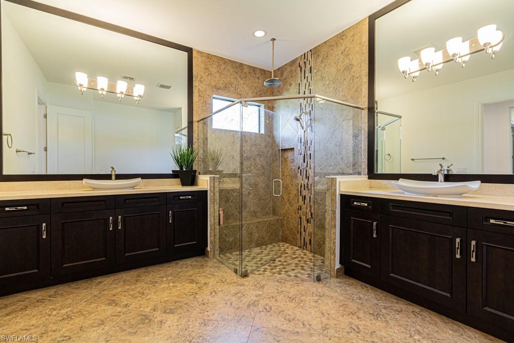 9380 Glenforest Drive Naples, FL 34120 - Photo 25 of 49 a bathroom with a sink and a mirror