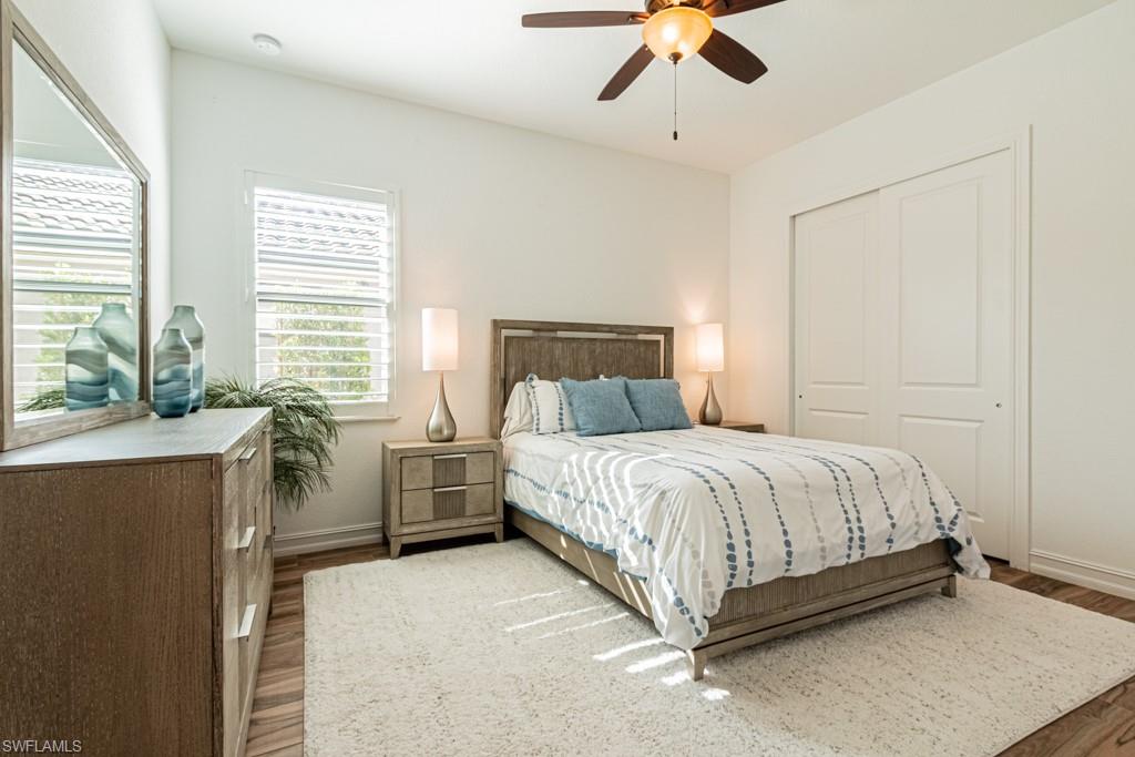 9380 Glenforest Drive Naples, FL 34120 - Photo 30 of 49 a bed room with a bed and a chandelier