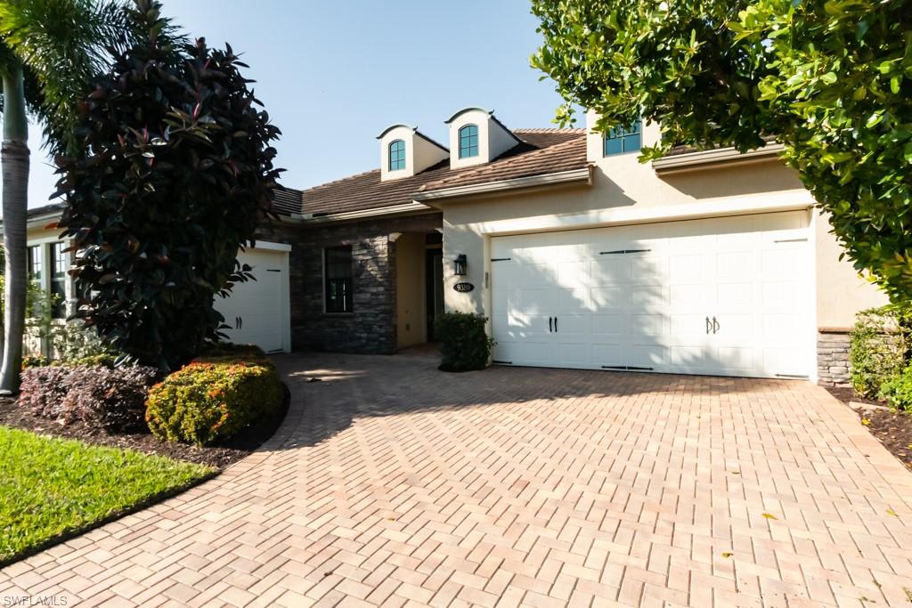 9380 Glenforest Drive Naples, FL 34120 - Photo 5 of 49 a front view of a house with a yard and garage