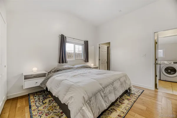 a bedroom with a bed and a lamp on dresser