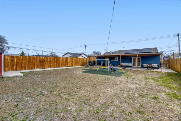 a view of a house with backyard and wooden fence