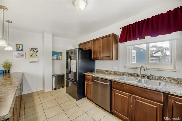 a kitchen with kitchen island granite countertop a sink counter top space appliances and cabinets