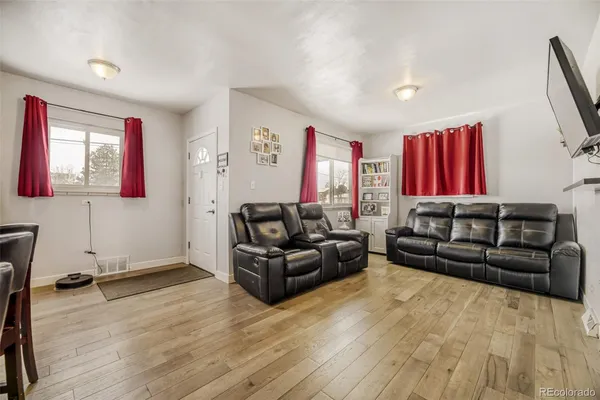 a living room with furniture and a wooden floor