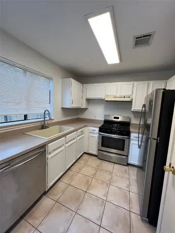 a kitchen with stainless steel appliances a refrigerator sink and microwave