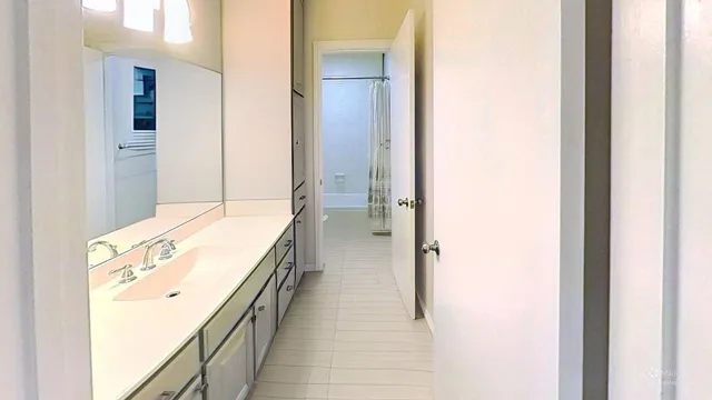 a spacious en suite bathroom with a granite countertop sink