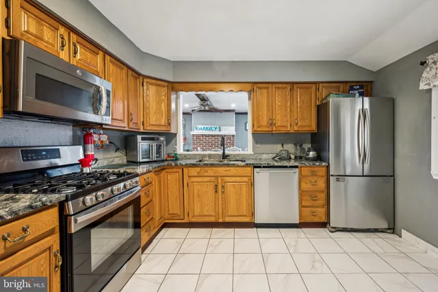 a kitchen with stainless steel appliances granite countertop a refrigerator stove top oven a sink and dishwasher