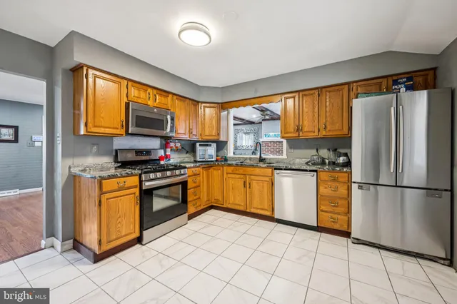 a kitchen with stainless steel appliances granite countertop a refrigerator sink and stove