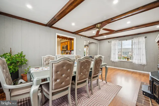 a dinning room with furniture a potted plant and wooden floor