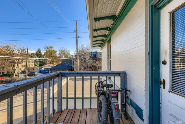 a view of a balcony with wooden floor and fence