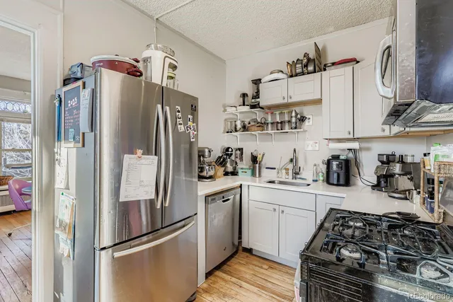 a kitchen with stainless steel appliances granite countertop a refrigerator and a sink