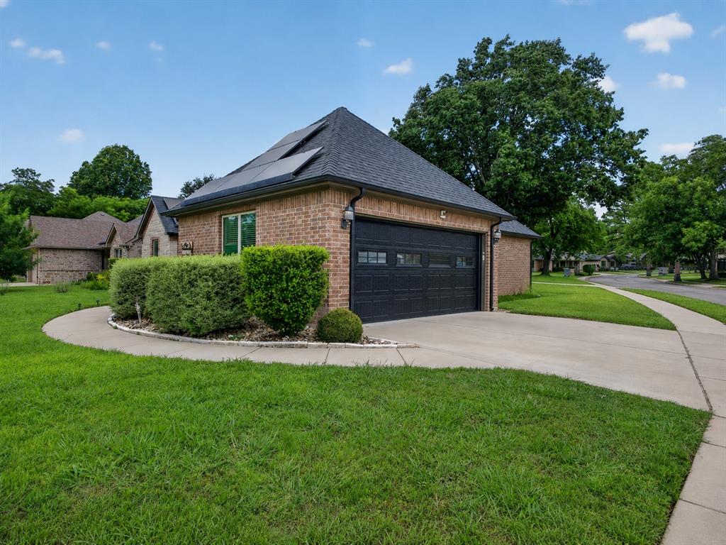 701 West Lamberth Road Sherman, TX 75092 - Photo 7 of 37 Brick exterior with a dark shingle roof and integrated solar panels