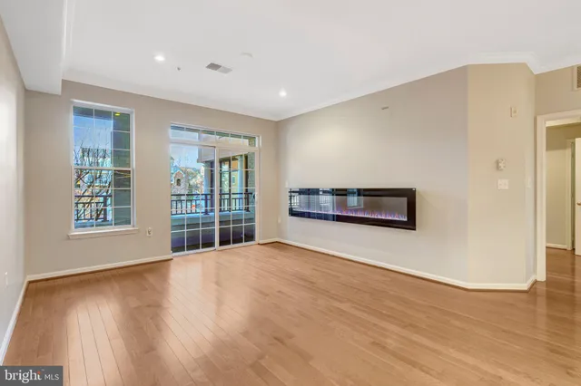 a view of an empty room with wooden floor