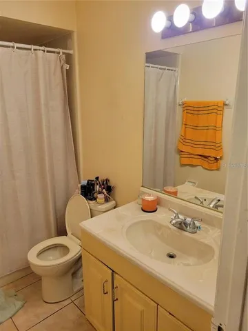 a bathroom with a sink a toilet and shower curtain