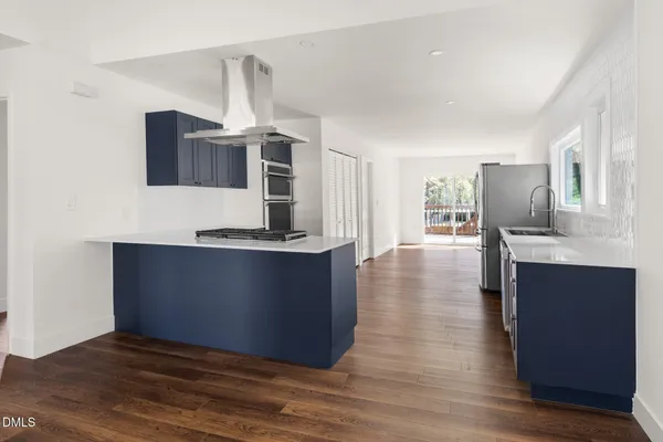a kitchen with stainless steel appliances granite countertop a stove cabinets and wooden floor