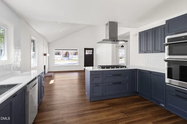 a view of a kitchen with refrigerator and wooden floor