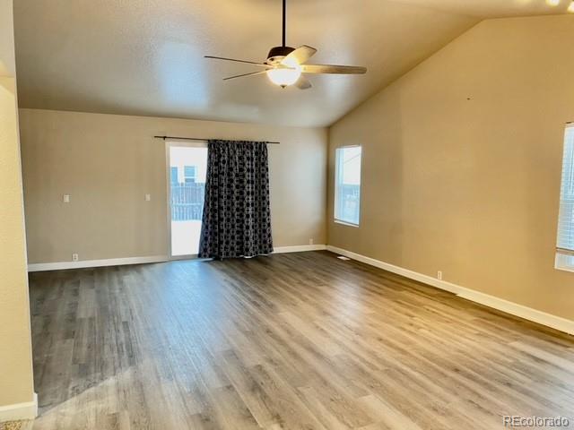 12337 Crystal Downs Road Peyton, CO 80831 - Photo 11 of 22 an empty room with wooden floor chandelier fan and windows