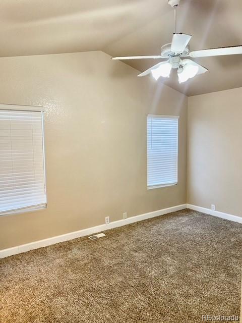 12337 Crystal Downs Road Peyton, CO 80831 - Photo 18 of 22 an empty room with a chandelier fan and windows