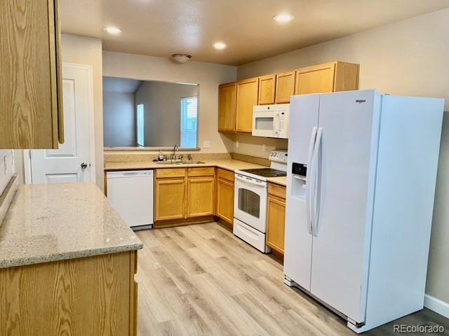 12337 Crystal Downs Road Peyton, CO 80831 - Photo 7 of 22 a kitchen with a sink a refrigerator and white cabinets
