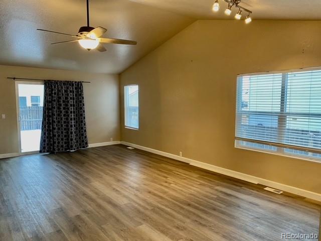 12337 Crystal Downs Road Peyton, CO 80831 - Photo 10 of 22 an empty room with wooden floor chandelier fan and windows