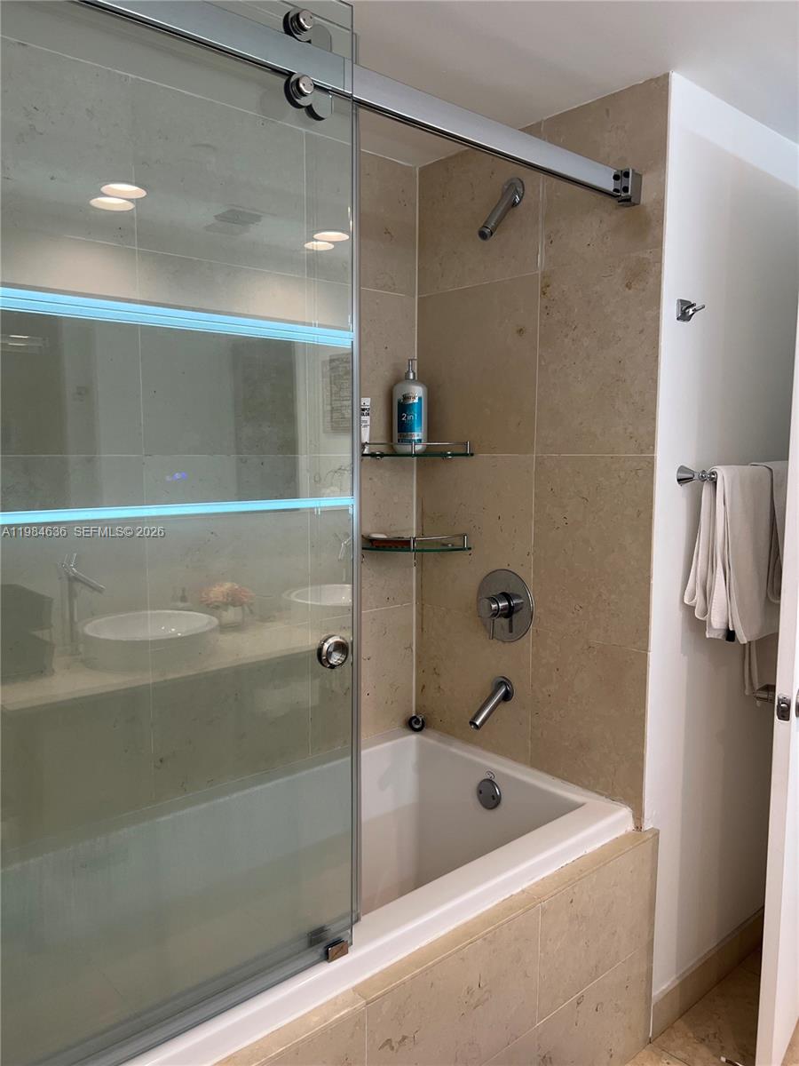 485 Brickell Avenue, Unit 4109 Miami, FL 33131 - Photo 13 of 15 a bathroom with a tub a mirror and a shower