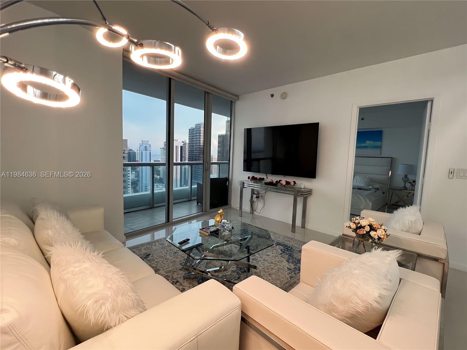 485 Brickell Avenue, Unit 4109 Miami, FL 33131 - Photo 3 of 15 a living room with furniture and a flat screen tv