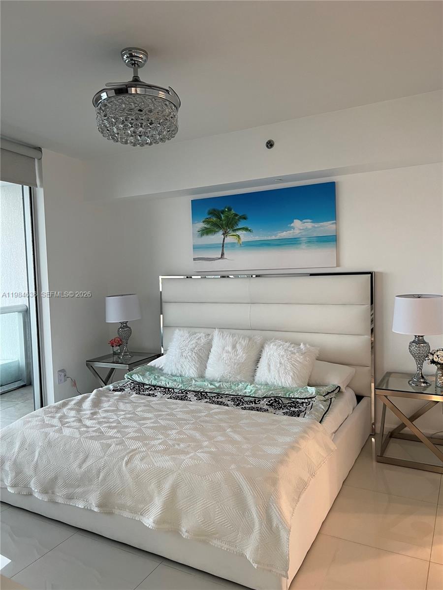 485 Brickell Avenue, Unit 4109 Miami, FL 33131 - Photo 9 of 15 a bedroom with a bed and a chandelier
