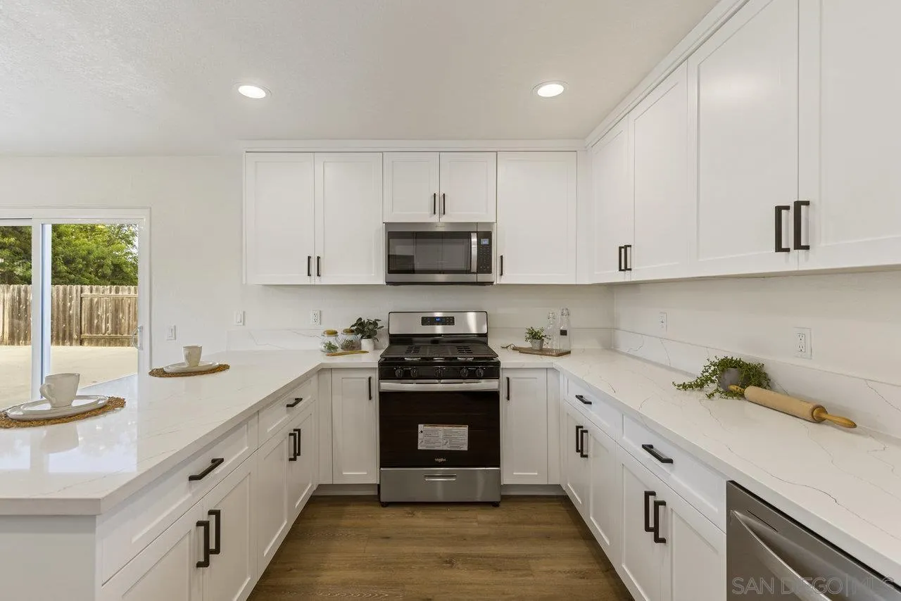 1066 Fulton Road San Marcos, CA 92069 - Photo 15 of 36 a kitchen with granite countertop white cabinets and a stove