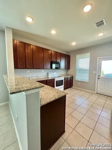 a kitchen with stainless steel appliances granite countertop a sink stove and cabinets