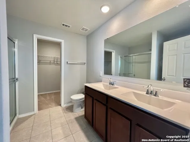 a bathroom with a double vanity sink toilet and shower