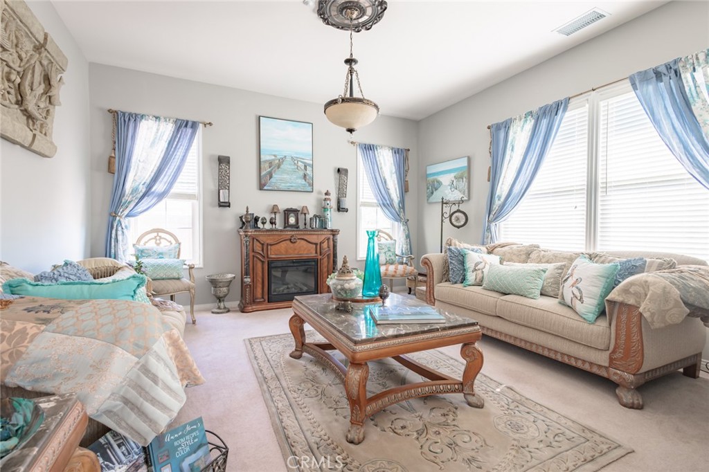 1045 Inverlochy Drive Fallbrook, CA 92028 - Photo 11 of 39 a living room with furniture a fireplace and a chandelier