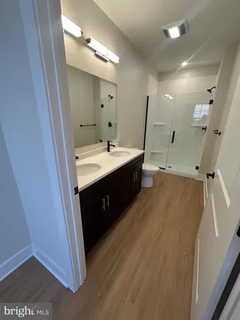 a spacious bathroom with a double vanity sink a mirror and a shower
