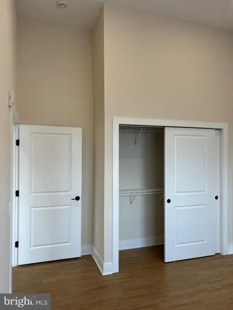 an empty room with wooden floor and closet