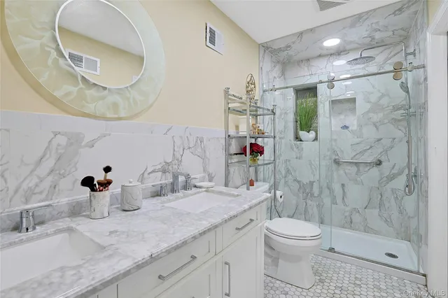 a bathroom with a granite countertop sink a toilet and shower