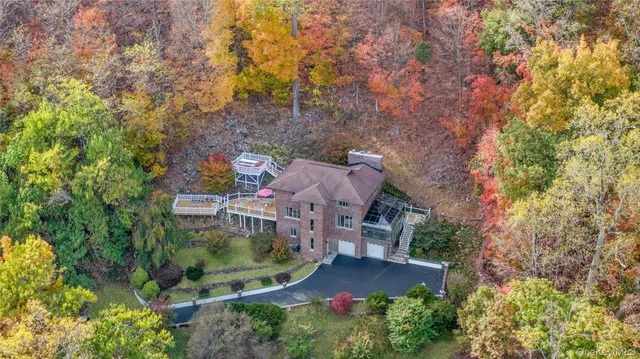 an aerial view of a house with a yard and lake view