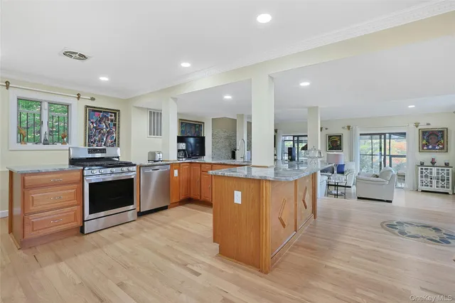 a large kitchen with stainless steel appliances granite countertop a large counter top a stove a sink and a refrigerator