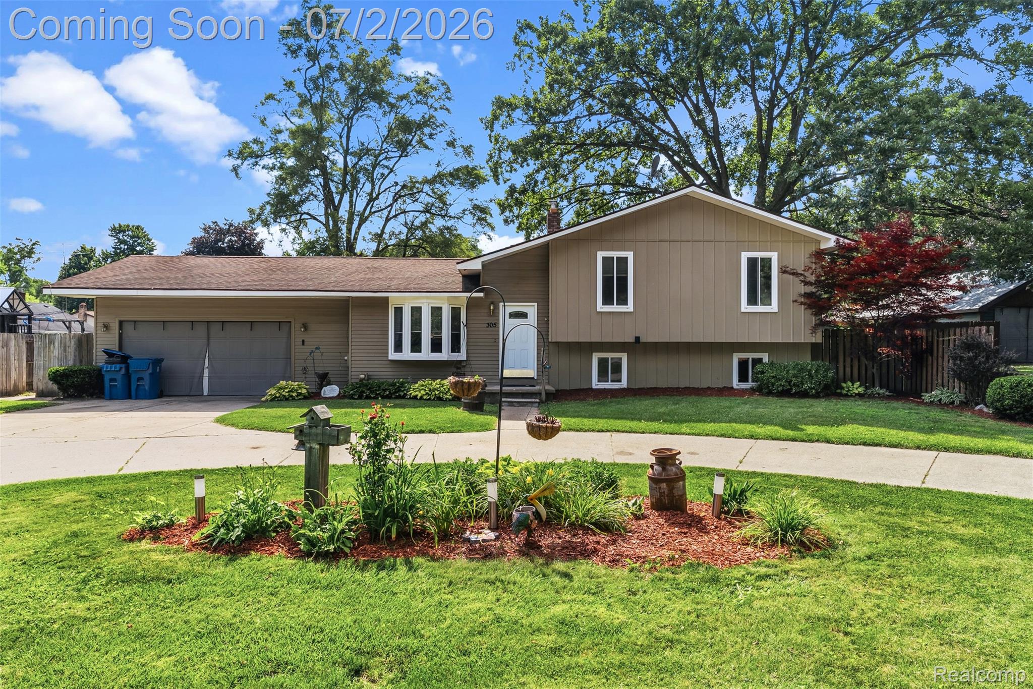 305 East Road Holly, MI 48442 - Photo 2 of 41 Split-level residence featuring a two-car garage, bay window, and a concrete driveway