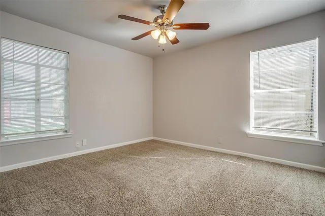 an empty room with a window and a fan