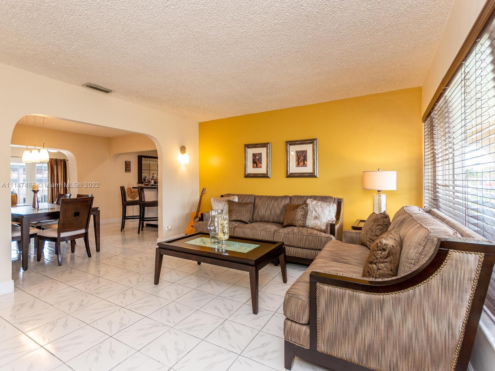 490 West 33rd Place Hialeah, FL 33012 - Photo 12 of 88 a living room with furniture and a lamp