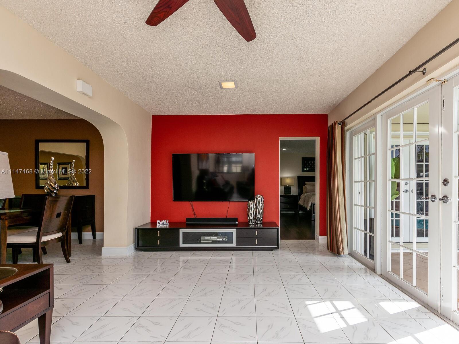 490 West 33rd Place Hialeah, FL 33012 - Photo 36 of 88 a living room with furniture gym equipment and a flat screen tv