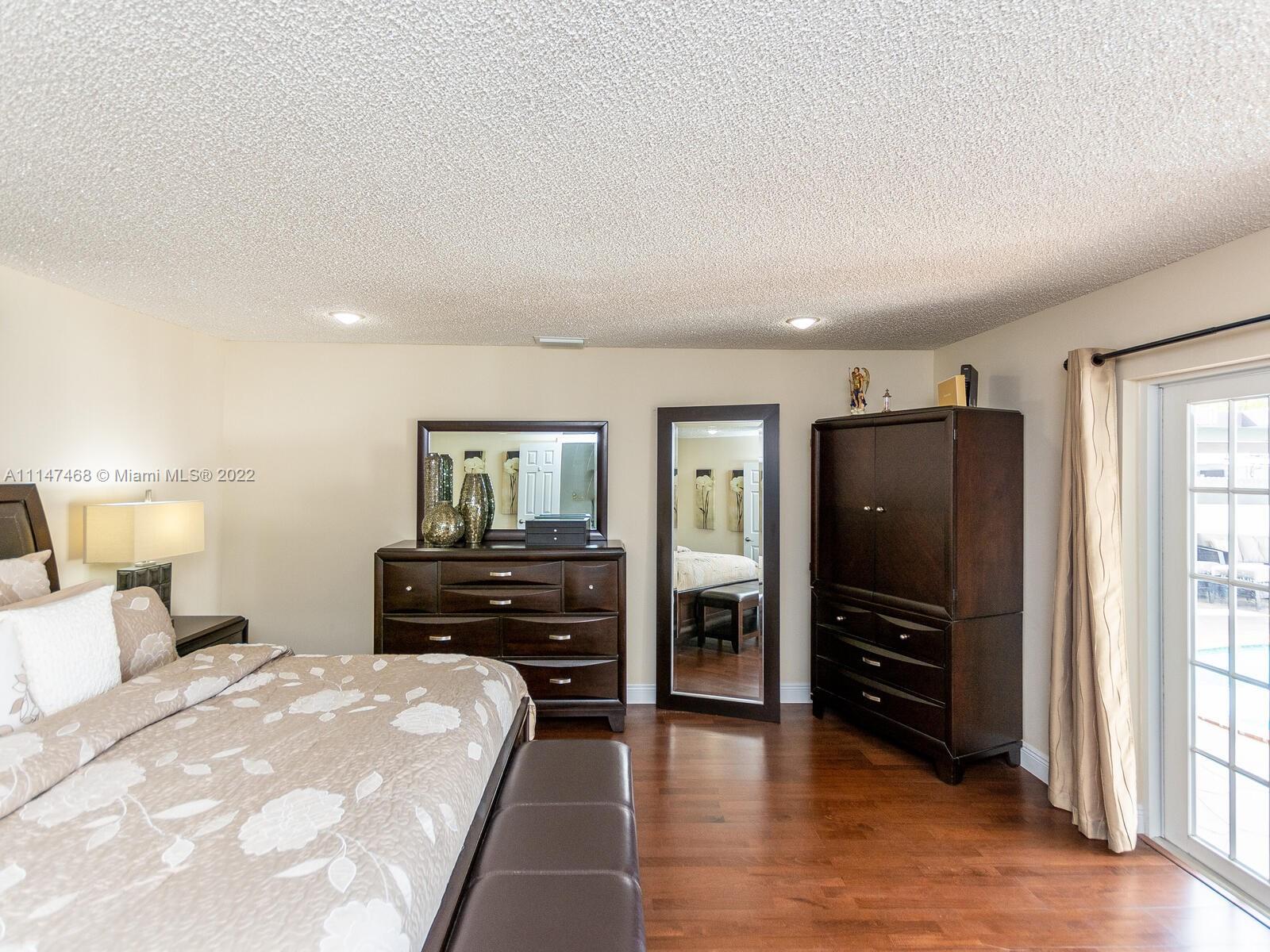 490 West 33rd Place Hialeah, FL 33012 - Photo 44 of 88 a bedroom with a bed and wooden floor