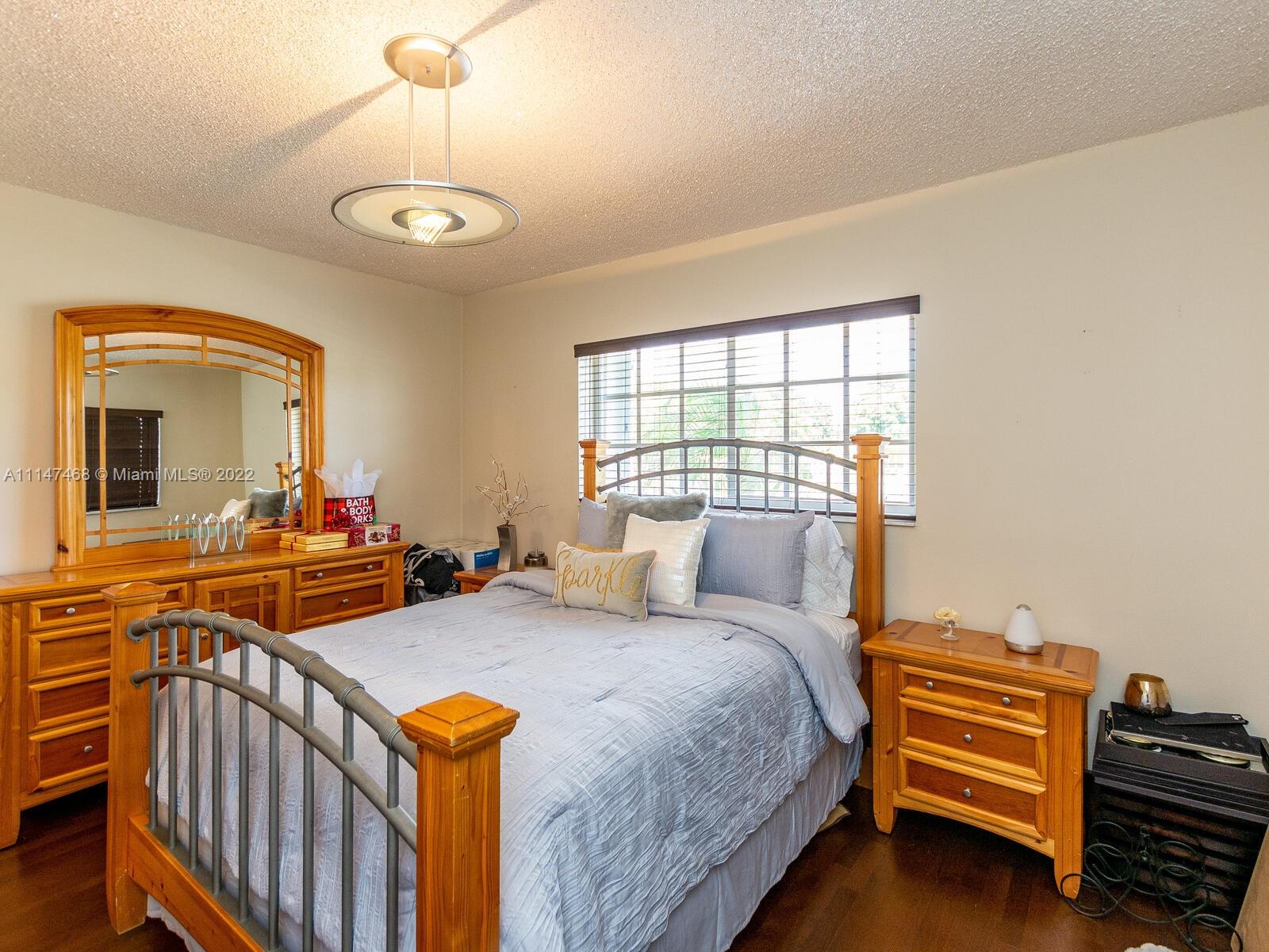 490 West 33rd Place Hialeah, FL 33012 - Photo 49 of 88 a bedroom with a bed and wooden floor