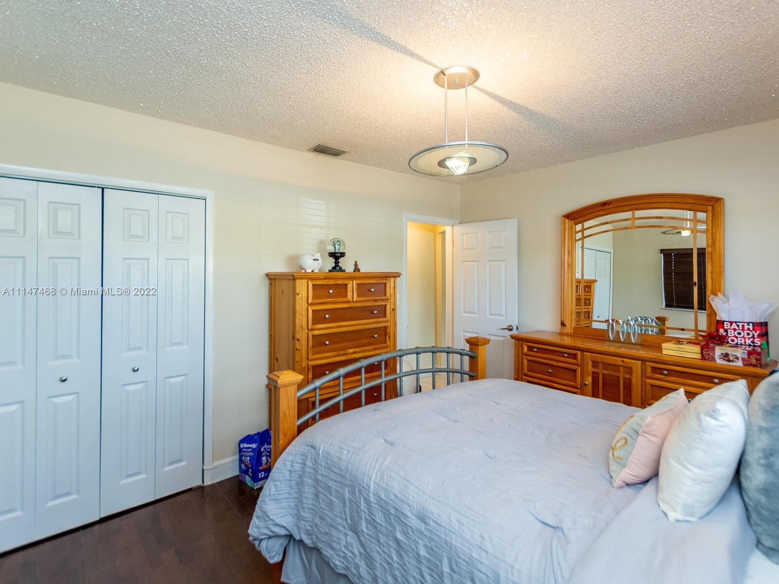 490 West 33rd Place Hialeah, FL 33012 - Photo 50 of 88 a bedroom with a bed and a chandelier