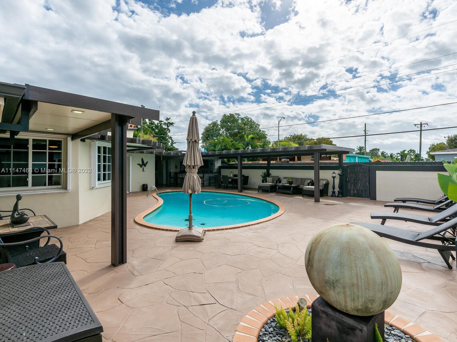 490 West 33rd Place Hialeah, FL 33012 - Photo 56 of 88 a view of a swimming pool with a patio and a garden