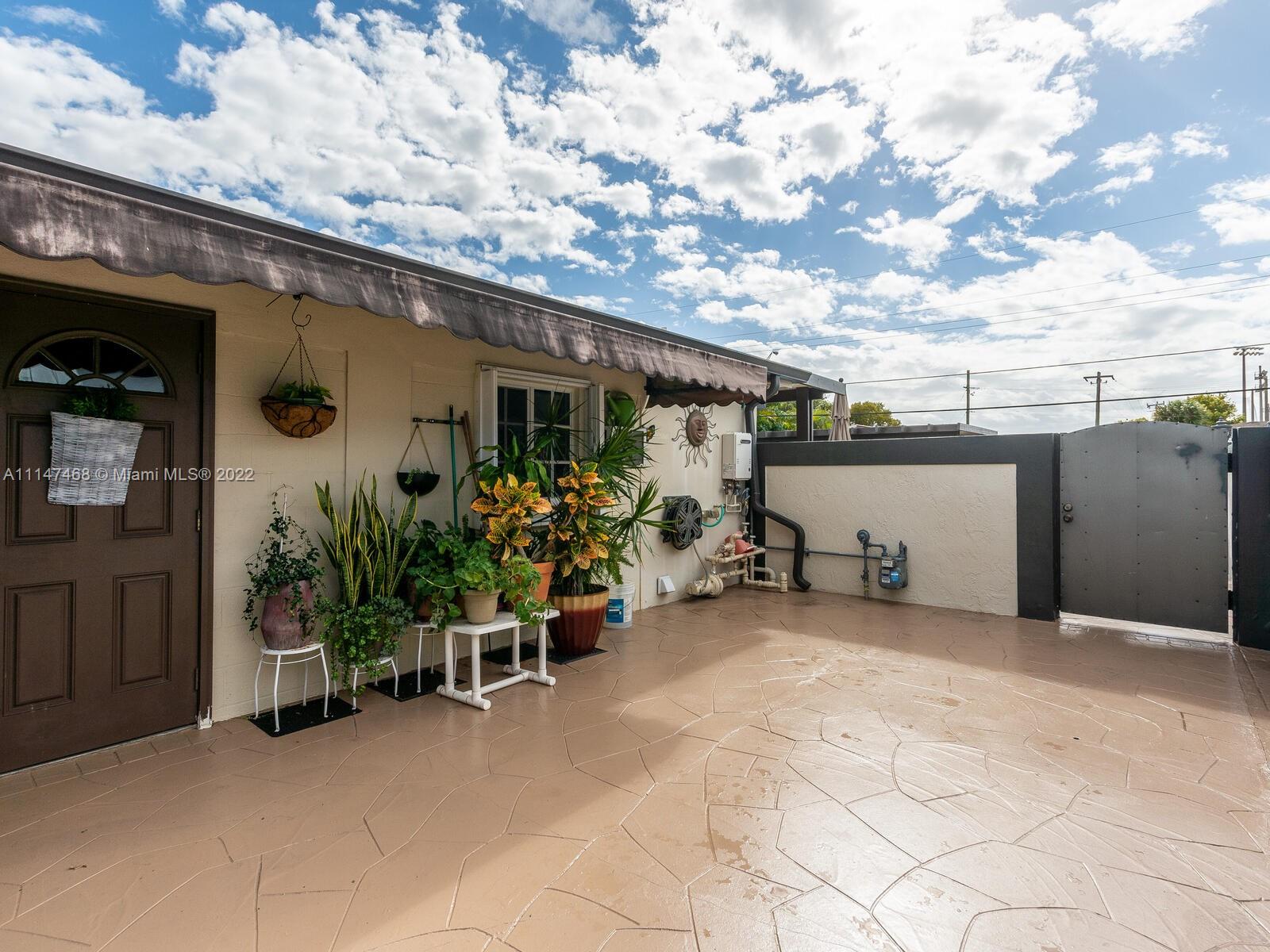 490 West 33rd Place Hialeah, FL 33012 - Photo 83 of 88 a view of a patio with table and chairs and potted plants