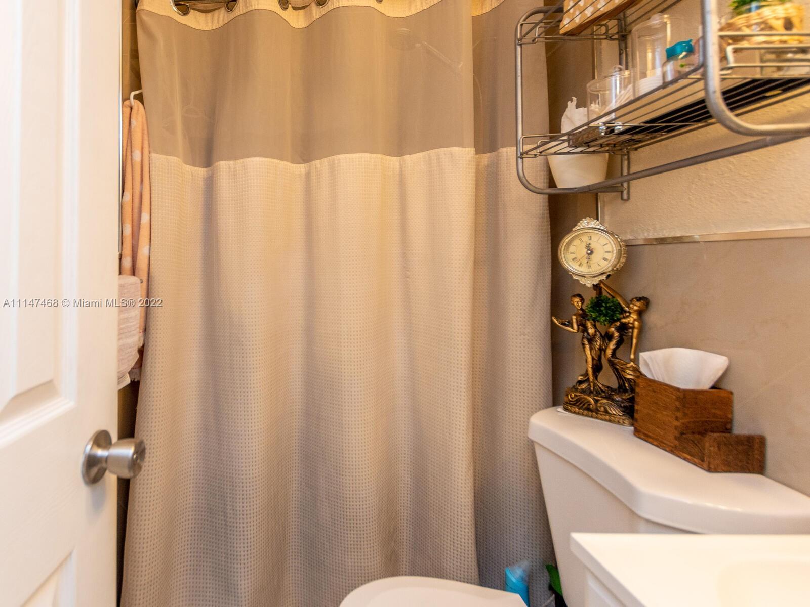 490 West 33rd Place Hialeah, FL 33012 - Photo 87 of 88 a bathroom with a sink a toilet and shower curtain