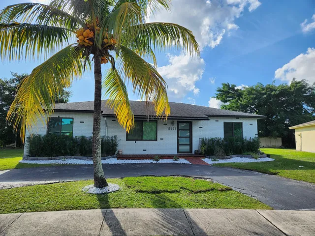 a front view of house with yard and tree