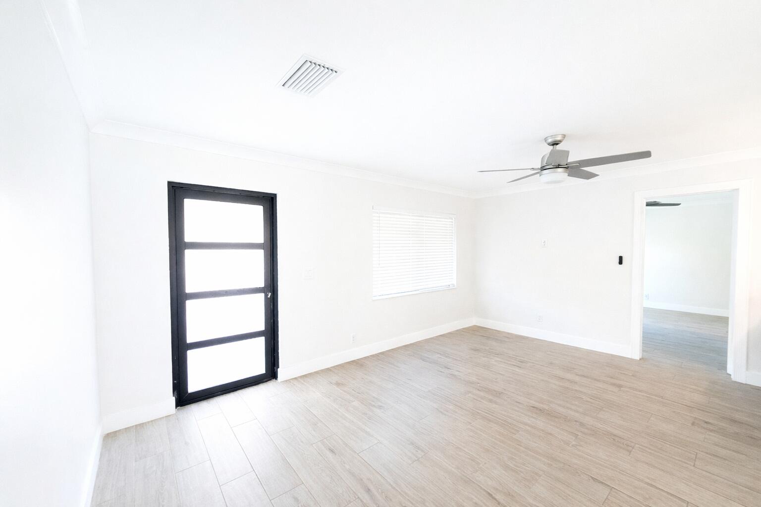 19471 Colorado Circle Boca Raton, FL 33434 - Photo 2 of 22 an empty room with wooden floor and windows