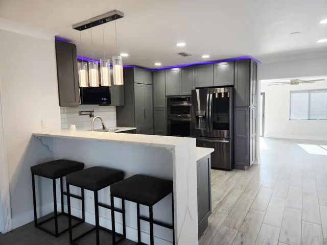 a kitchen with stainless steel appliances kitchen island granite countertop a refrigerator and a stove top oven