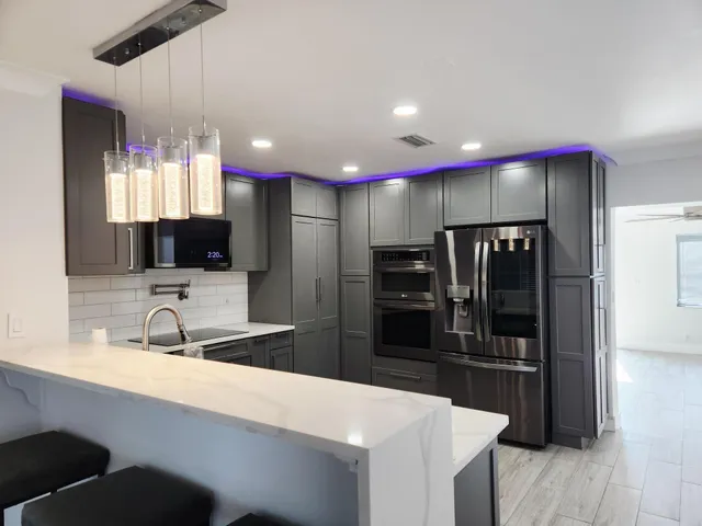 a kitchen with stainless steel appliances kitchen island granite countertop a sink and a refrigerator
